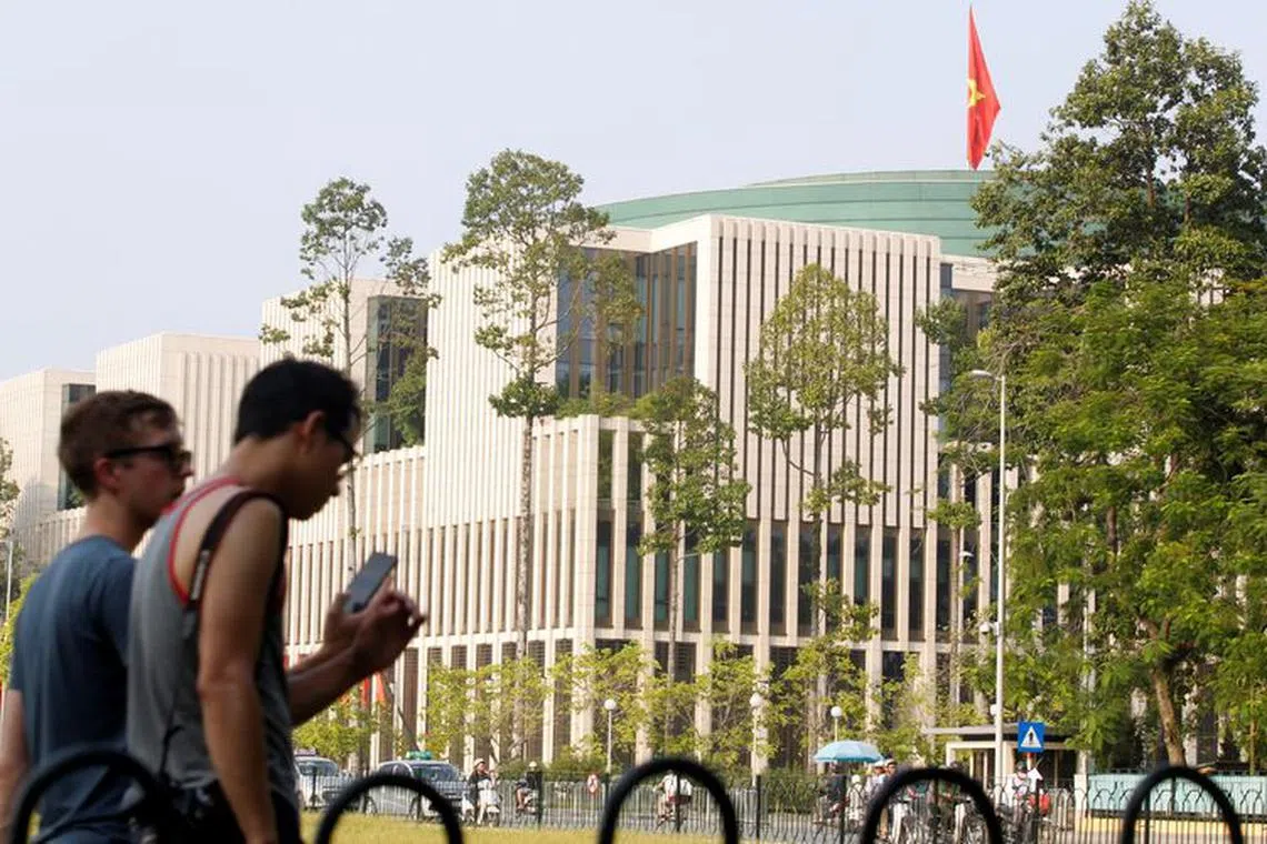 FILE PHOTO: Tourists walk past Vietnam's National Assembly (Parliament) building in Hanoi, Vietnam, September 16, 2016. REUTERS/Kham/File photo