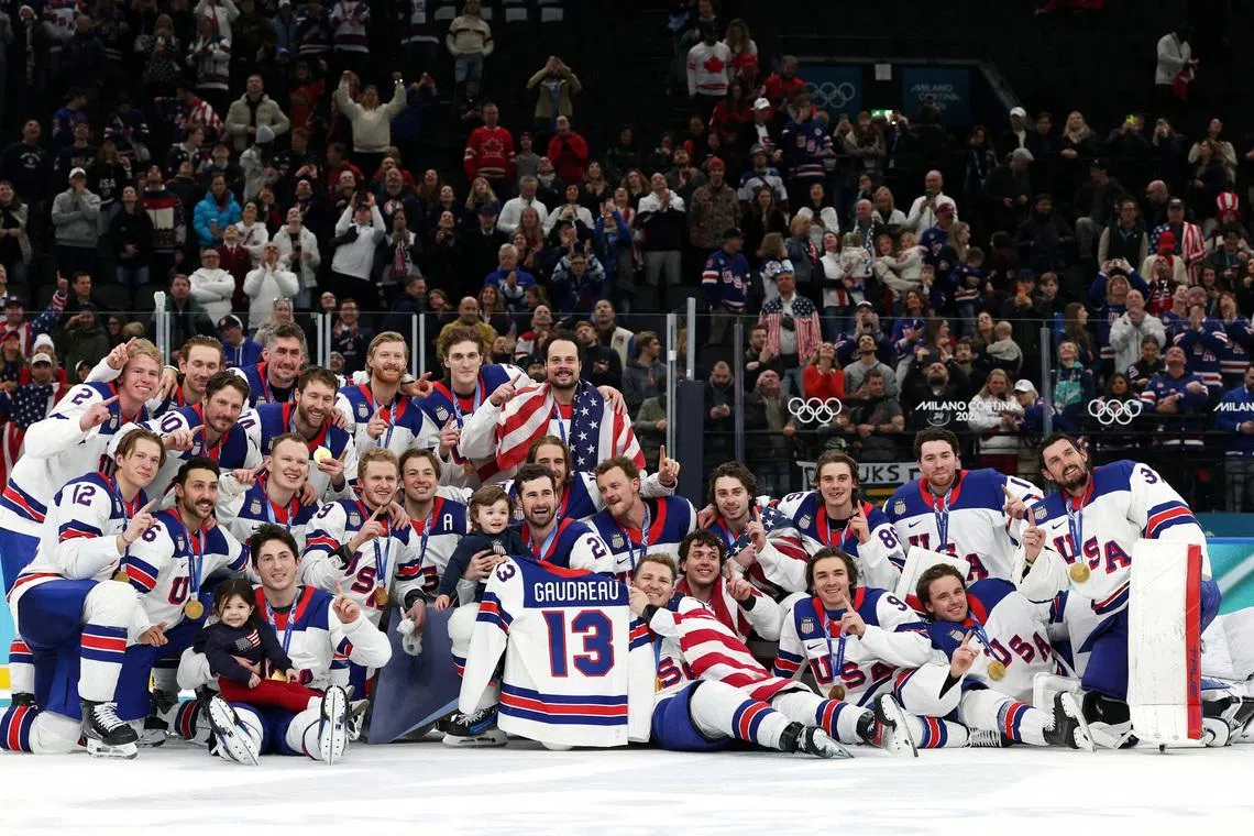 Milano Cortina 2026 Olympics - Ice Hockey - Men's Victory Ceremony - Milano Santagiulia Ice Hockey Arena, Milan, Italy - February 22, 2026. Gold medalists United States hold up the jersey of the late John Gaudreau and celebrate with his children, Noa Harper Gaudreau and Johnny Edward Gaudreau, as they pose for a photograph and celebrate with their medals during the ceremony REUTERS/Mike Segar