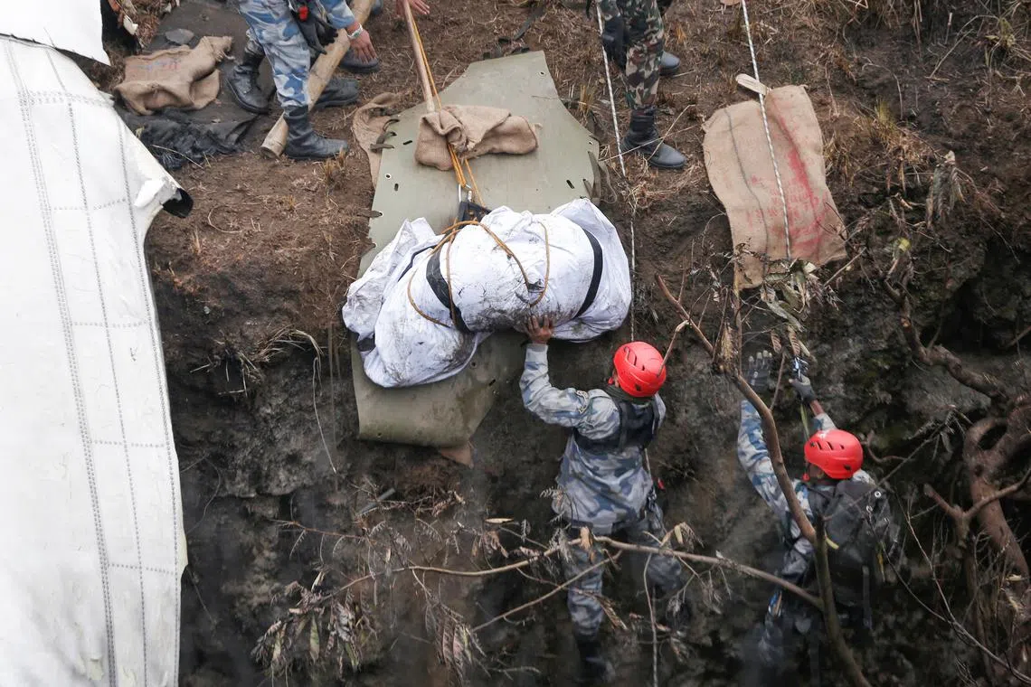 A rescue team recovers the body of a victim from the site of the plane crash of a Yeti Airlines operated aircraft, in Pokhara, Nepal, Jan 16, 2023.