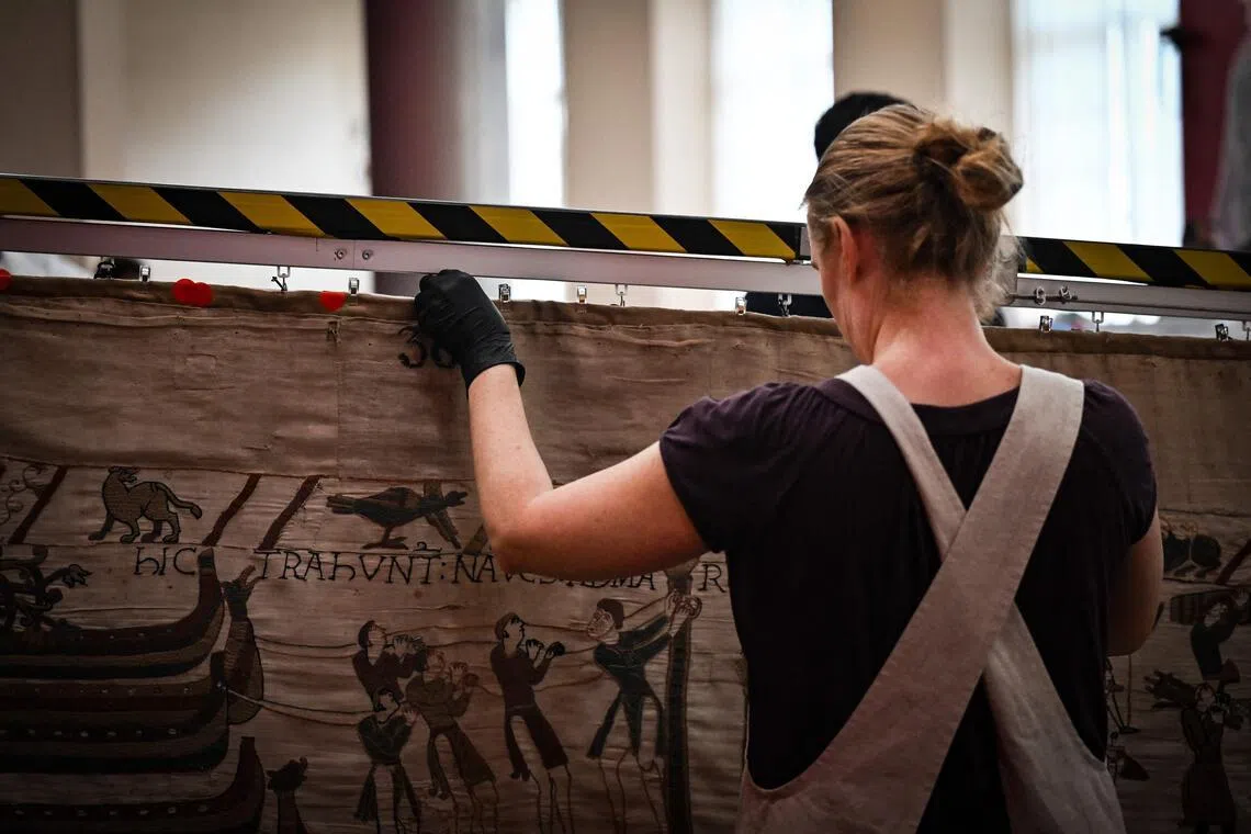 A worker prepares to pack the Bayeux Tapestry in a crate for transfer to the British Museum.