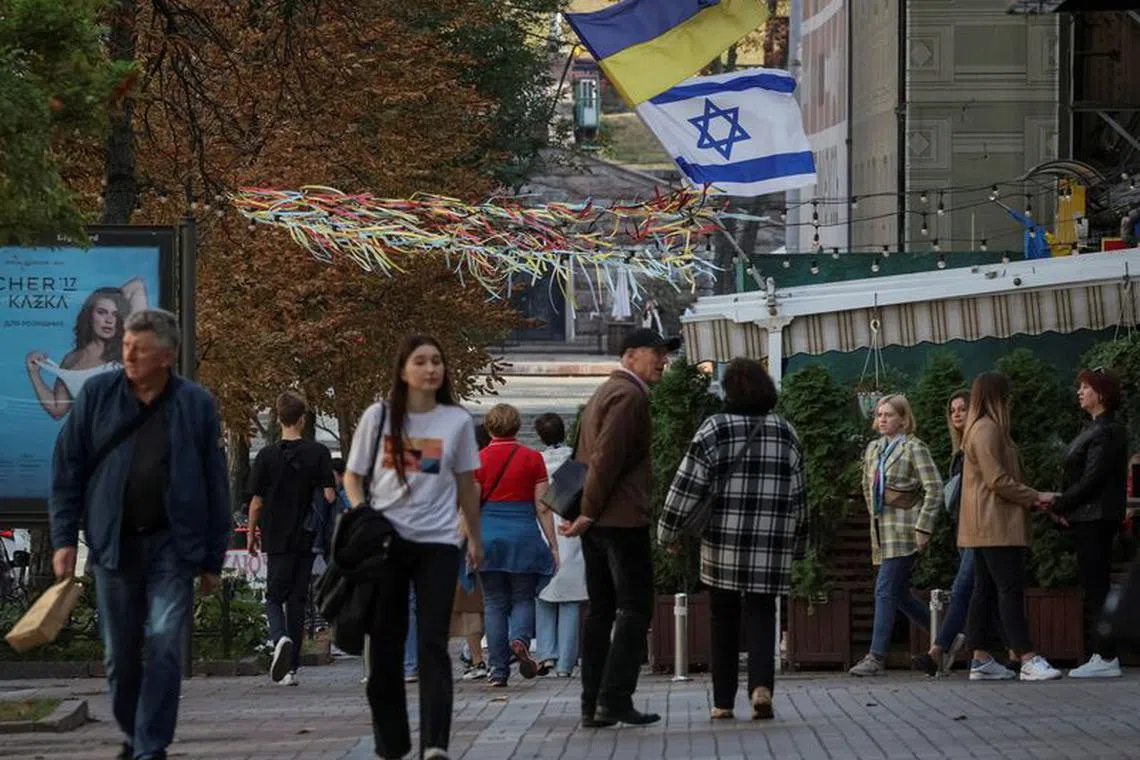 FILE PHOTO: An Israeli flag flies next to a Ukrainian flag, in support of Israel, amid the ongoing conflict between Israel and the Palestinian Islamist group Hamas and amid Russia's attack on Ukraine, in central Kyiv, Ukraine October 14, 2023. REUTERS/Gleb Garanich/File Photo