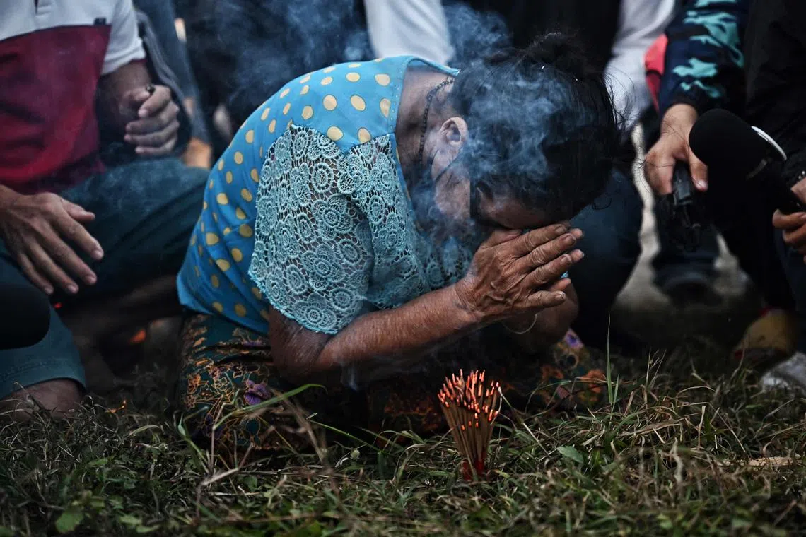 A relative of a missing sailor praying while awaiting news after the sinking of Thai naval vessel HTMS Sukhothai.