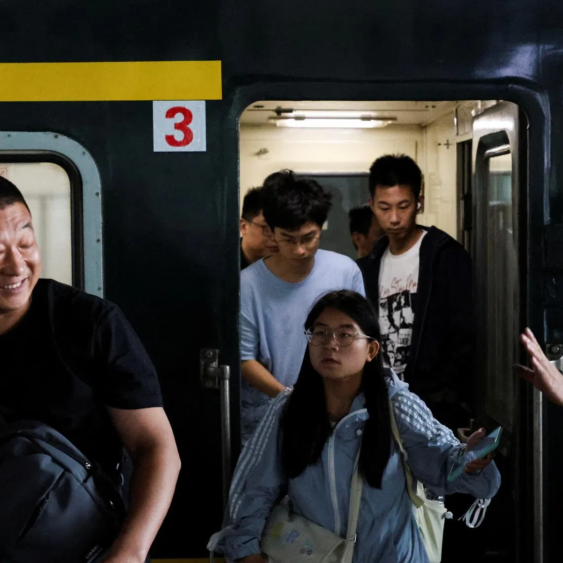People disembark from a train after arriving at Hangzhou South Railway Station during the five-day Labour Day holiday in Hangzhou, China May 4, 2025. REUTERS/Go Nakamura
