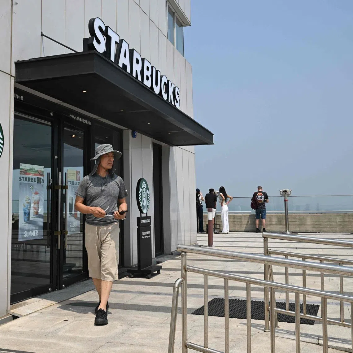 A visitor walks past a Starbucks store offering a view of North Korea at a South Korean observation deck at Aegibong Peace Ecopark in Gimpo on July 1.