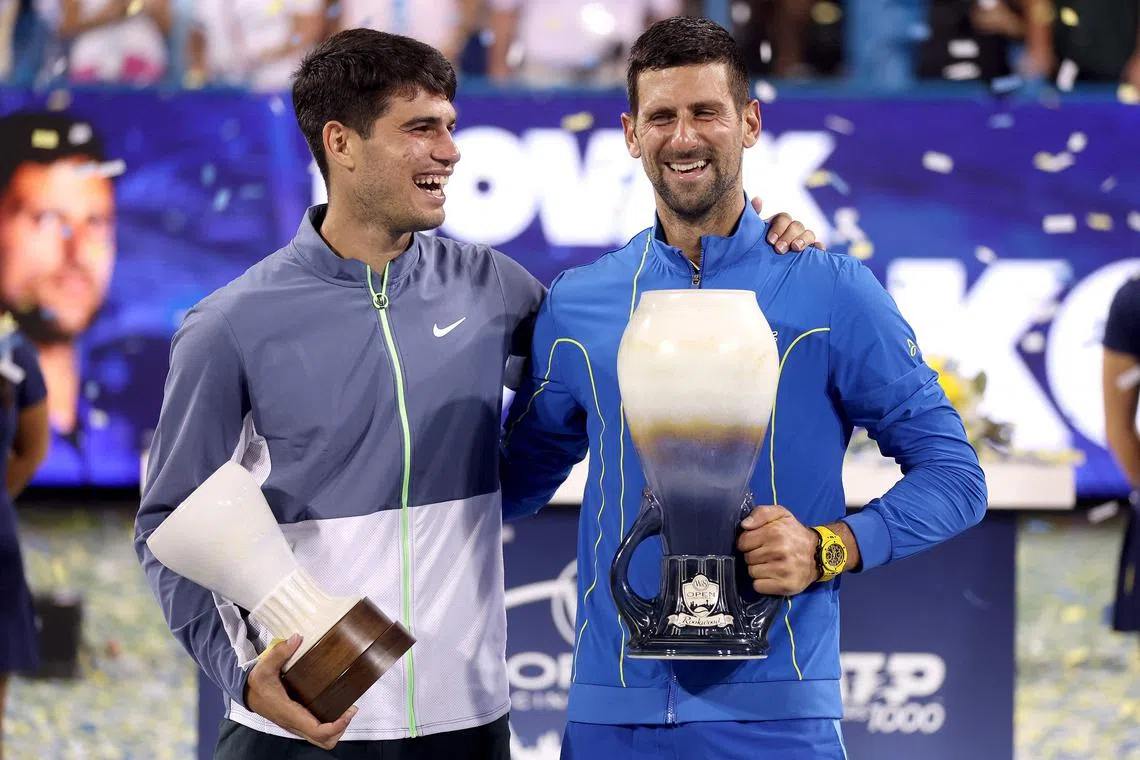 Carlos Alcaraz and Novak Djokovic pose with their trophies after the final of the Western & Southern Open.