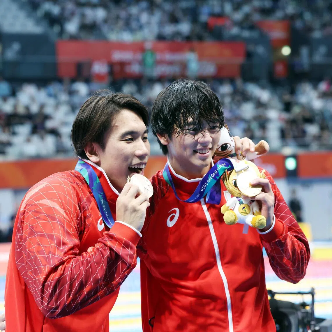 Japan’s Shoon Mitsunaga (right) celebrates with bronze medallist Katsuhiro Matsumoto after winning the Asian Games men’s 100m butterfly final.