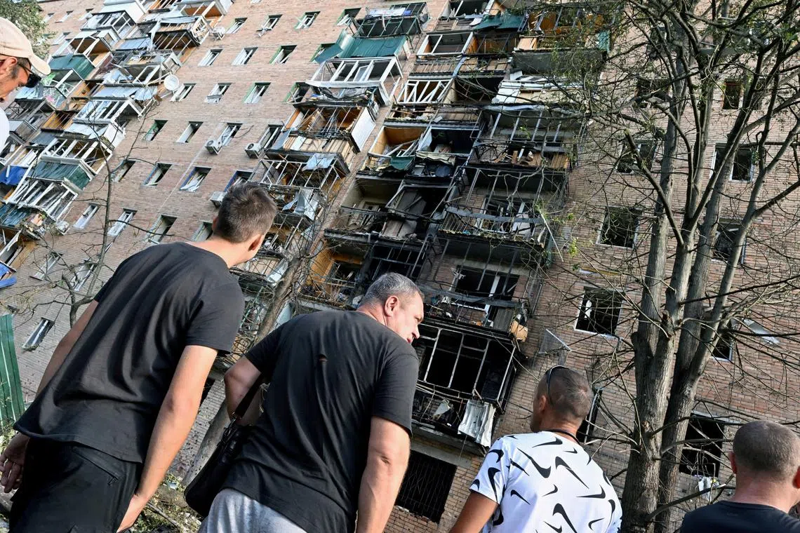 FILE PHOTO: People gather in the courtyard of a multi-storey residential building, which according to local authorities was hit by debris from a destroyed Ukrainian missile, in the course of Russia-Ukraine conflict in Kursk, Russia August 11, 2024. Kommersant Photo/Anatoliy Zhdanov via/File Photo