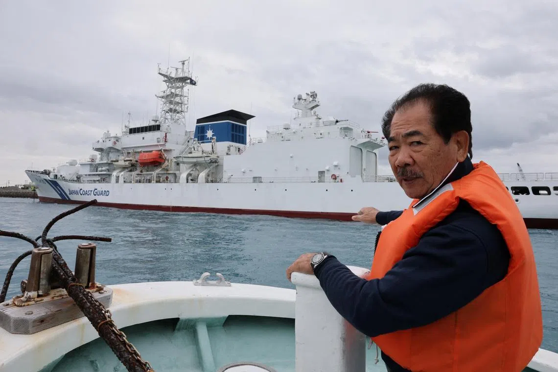 Hitoshi Nakama, a fisherman and local councilor in Ishigaki who has been fishing around a group of disputed islands called Senkaku Islands in Japan, also known in China as Diaoyu Islands, speaks during an interview with Reuters as his fishing boat sails past Japan coast guard ship docked at a port in Ishigaki, Okinawa Prefecture, Japan, January 13, 2026. REUTERS/Kim Kyung-Hoon