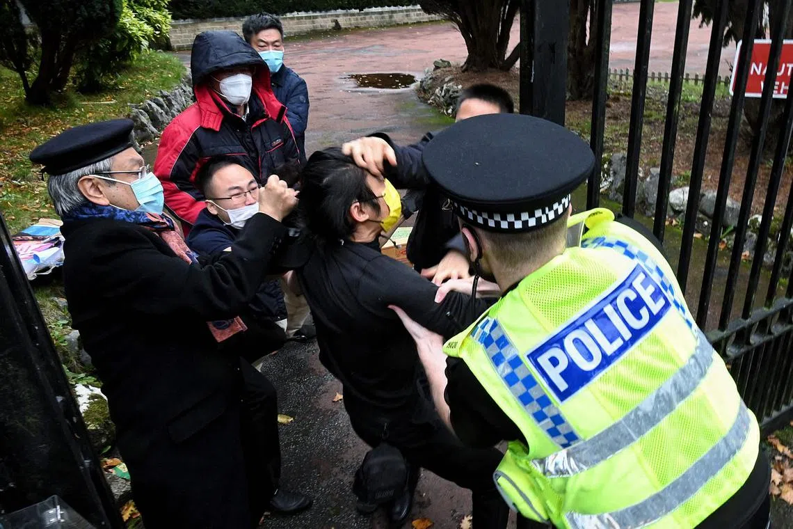 A police officer trying to break up a scuffle between a pro-democracy protester and consulate staff at the Chinese consulate in Manchester on Oct 16, 2022.