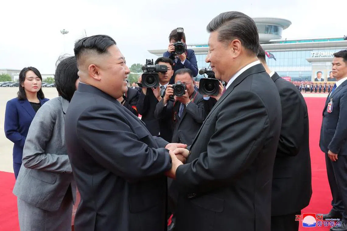 FILE PHOTO: North Korean leader Kim Jong Un shakes hands with Chinese President Xi Jinping during Xi's visit in Pyongyang, North Korea, in this picture released by by North Korea's Korean Central News Agency (KCNA) on June 21, 2019.    KCNA via REUTERS/File Photo