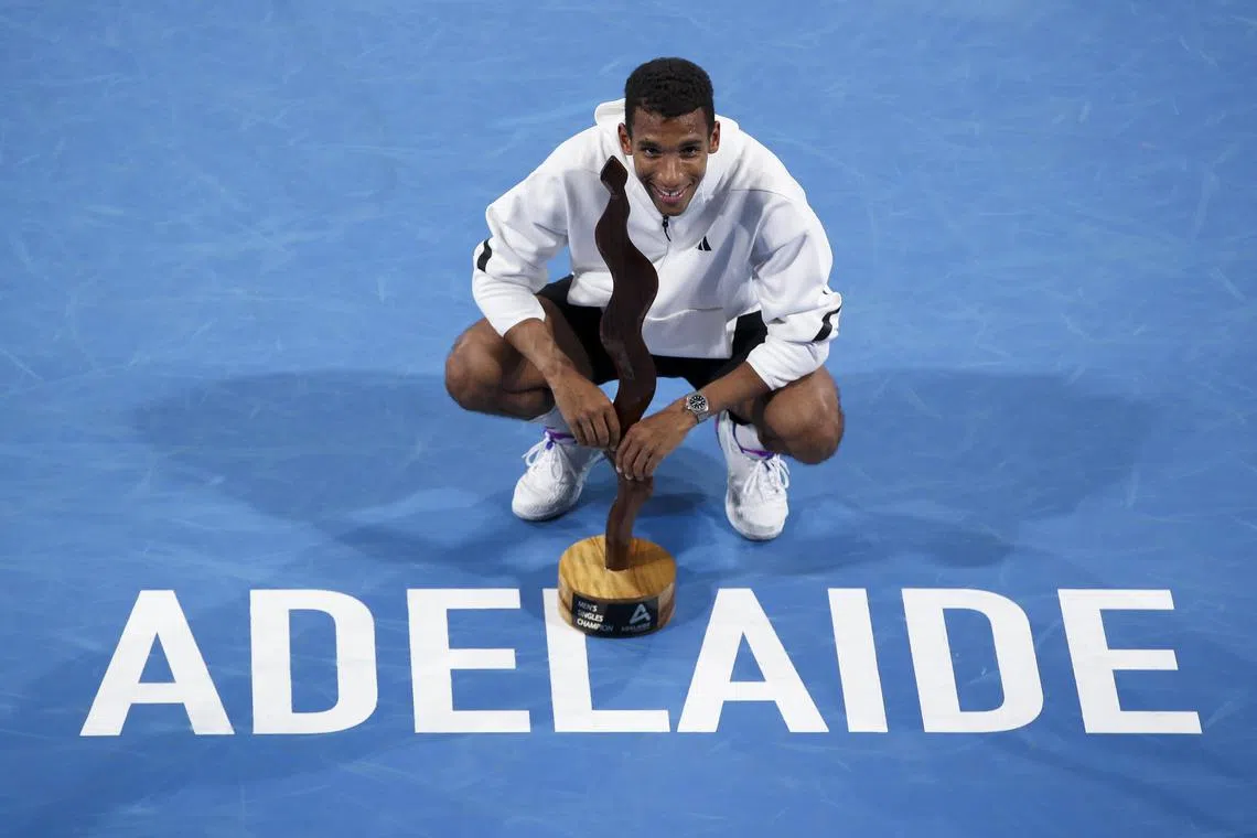 Canada's Felix Auger-Aliassime posing with the trophy after winning his men's final against Sebastian Korda of the US.