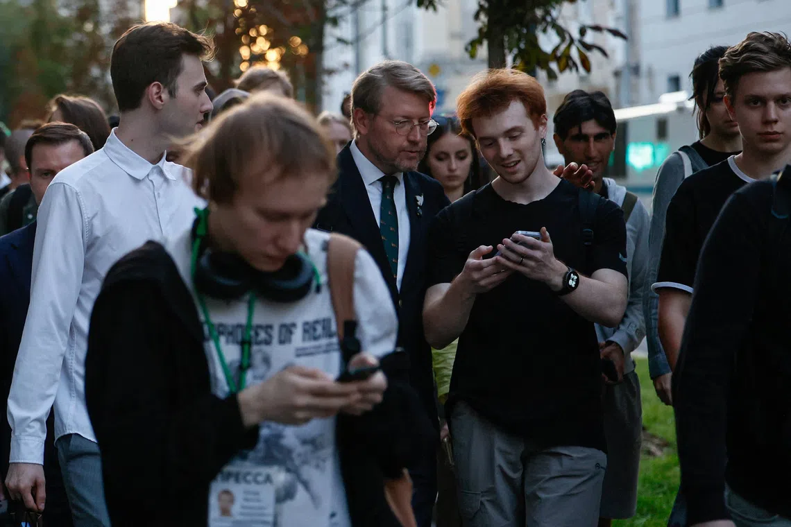 A group of people gathered outdoors on a city street.
