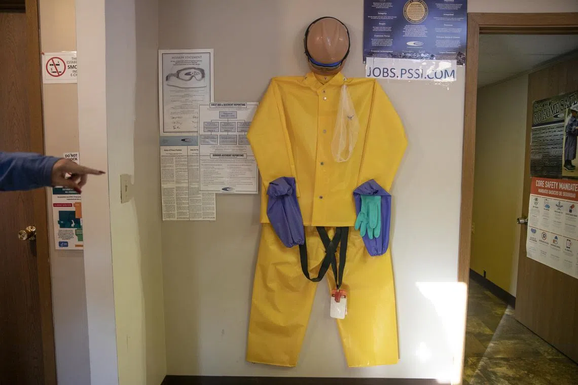 Protective equipment hangs in a recruiting office for Packers Sanitation Services, where migrant children were hired to clean slaughterhouses overnight, in Worthington, Minnesota.