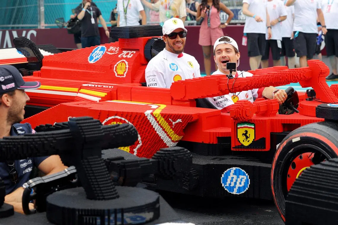 Formula One F1 - Miami Grand Prix - Miami International Autodrome, Miami, Florida, United States - May 4, 2025 Ferrari's Charles Leclerc and Lewis Hamilton in a full sized Lego replica F1 car during the drivers parade REUTERS/Brian Snyder
