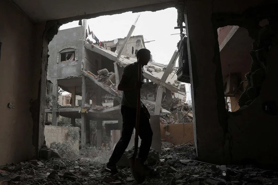 A Palestinian man inspecting the damage at the site of an Israeli strike, in the central Gaza Strip, May 18, 2025. 