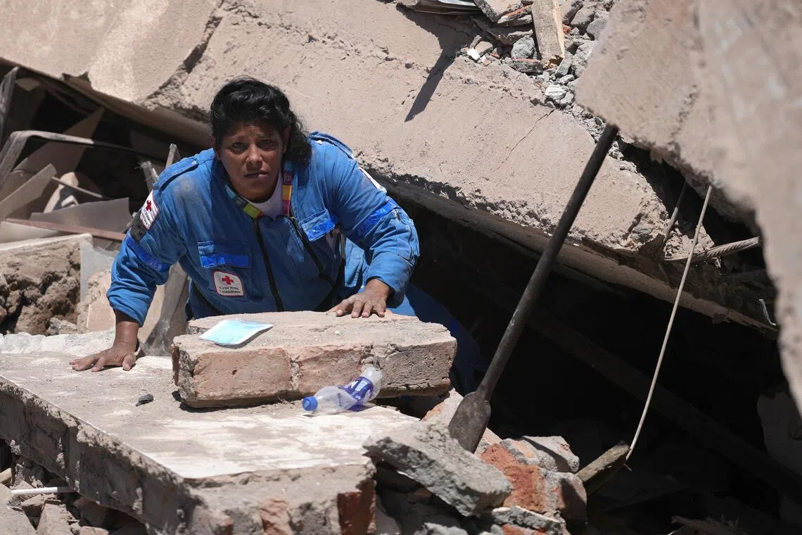 A member of the Colombian Red Cross searching through the rubble of a collapsed building in Cali, Colombia, after an Aug 10 earthquake.