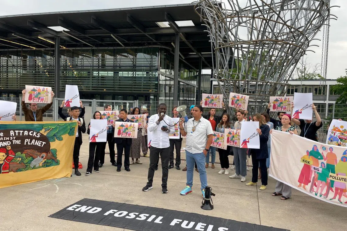 Activists hold an anti-fossil fuel protest at the pre-COP28 climate conference, in Bonn, Germany.