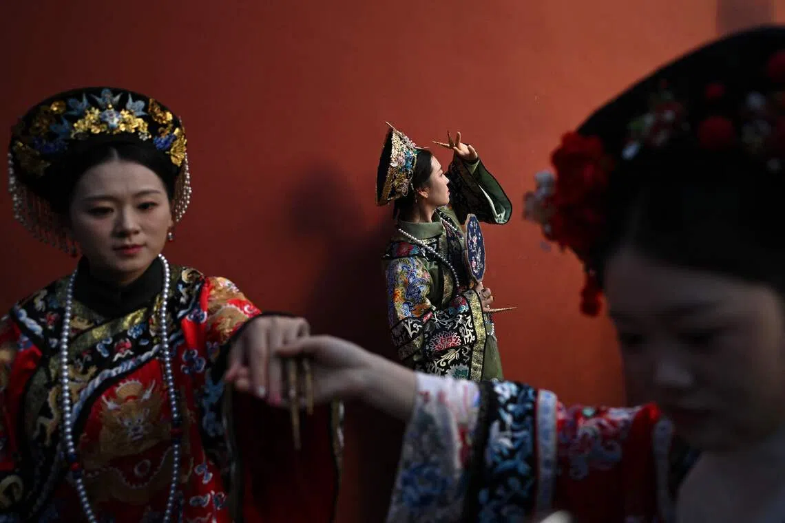 Women wearing traditional Chinese costumes posing for photographs as they visit the Forbidden City in Beijing during China's National Day Golden Week holiday on Oct 6, 2025.