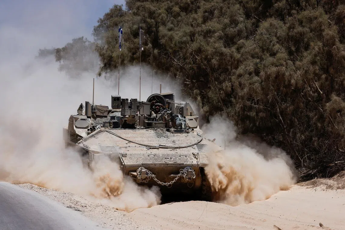 FILE PHOTO: An Israeli military vehicle manoeuvres near the Israel-Gaza border, amid the Israel-Hamas conflict, in Israel, July 10, 2024. REUTERS/Amir Cohen/File Photo