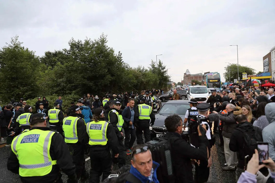 Police officers stand guard between protesters (right) defending the Abdullah Quilliam Mosque in Liverpool on Aug 2 against the 'Enough is Enough' demonstration (left) called in reaction to the fatal stabbings in Southport on July 29. UK police prepared for planned far-right protests and other demonstrations this weekend, after two nights of unrest in several English towns and cities following a mass stabbing that killed three young girls. 