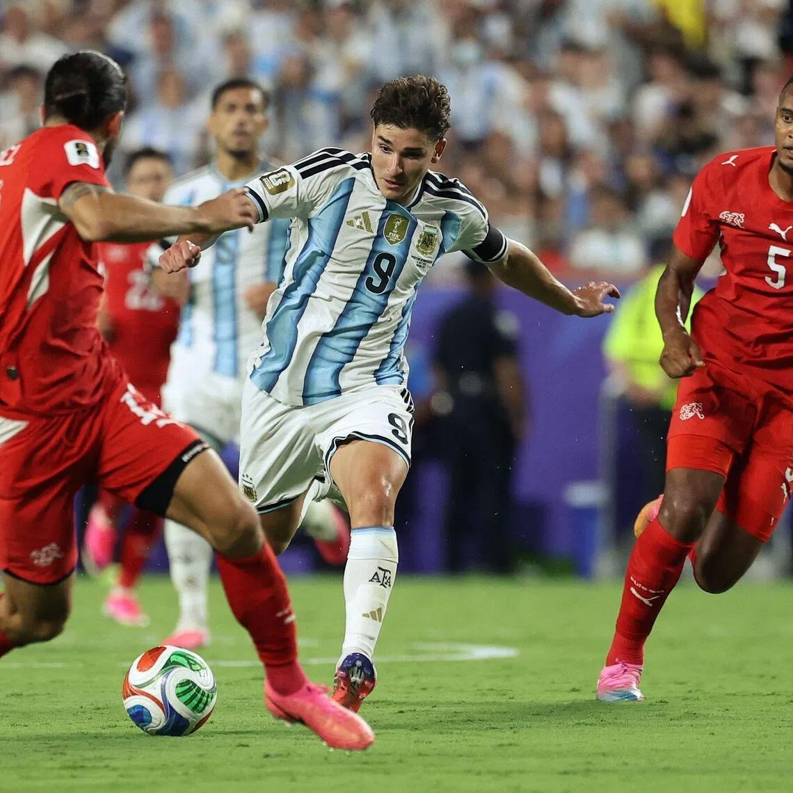 Argentina's forward #09 Julian Alvarez runs with the ball as Switzerland's defender #13 Ricardo Rodriguez and Switzerland's defender #05 Manuel Akanji defend during the 2026 World Cup football tournament quarter-final match between Argentina and Switzerland at the Kansas City Stadium in Kansas City on July 11, 2026.  (Photo by Thomas COEX / AFP)