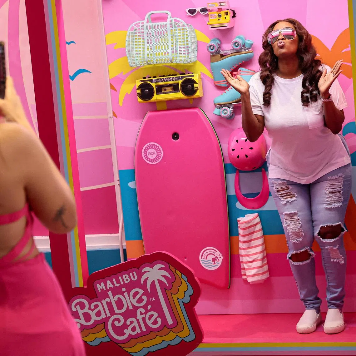 A guest poses for photos at the new Malibu Barbie Cafe pop-up in New York City, U.S., May 17, 2023.  REUTERS/Brendan McDermid    