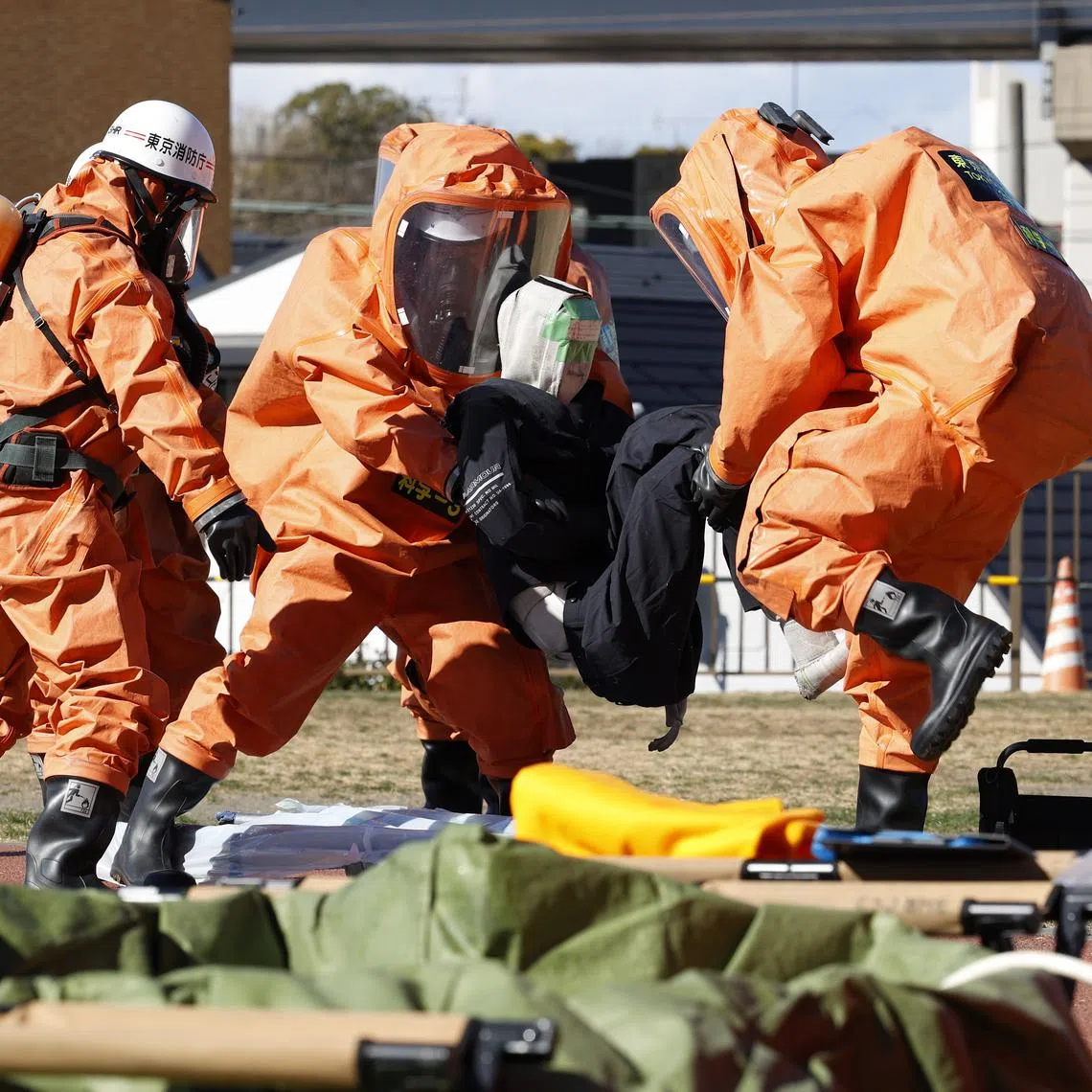 Firefighters in protective gear taking part in a drill simulating missile attack in Tokyo, on Feb 4.