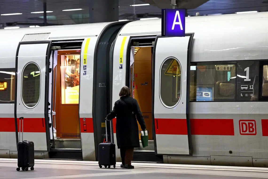 FILE PHOTO: A passenger walks to enter a high-speed train ICE of Deutsche Bahn railway operator at the main station in Berlin, Germany, March 4, 2024. REUTERS/Lisi Niesner/File Photo