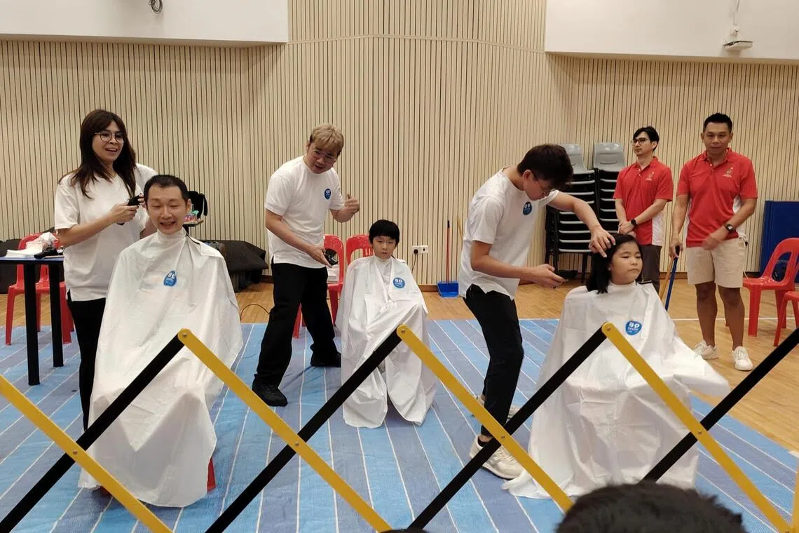 Joy Ang, 9 (right), with her father Kelvin Ang (left), 44, and her twin brother Jay Ang, 9 shaving their heads at Kong Hwa School’s Hair for Hope event on May 22.