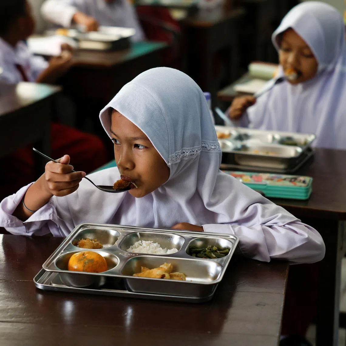Students eat meals from the free nutritious meals program at a school in Jakarta, Indonesia, January 6, 2025. REUTERS/Willy Kurniawan
