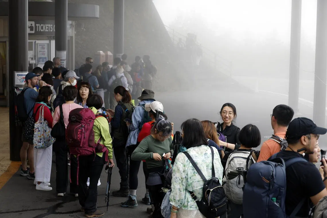 epa11596008 Tourists line up at a bus stop before leaving Mount Fuji 5th station in Yamanashi prefecture, Japan, 10 September 2024, the day of the end of the 2024 climbing season. According to preliminary data released by Japan's Environment Ministry, the maximum daily number of hikers climbing Mt. Fuji decreased by 20 percent in 2024 compared to 2023. This season saw the implementation of measures aimed at reducing congestion on the volcano.  EPA-EFE/FRANCK ROBICHON
