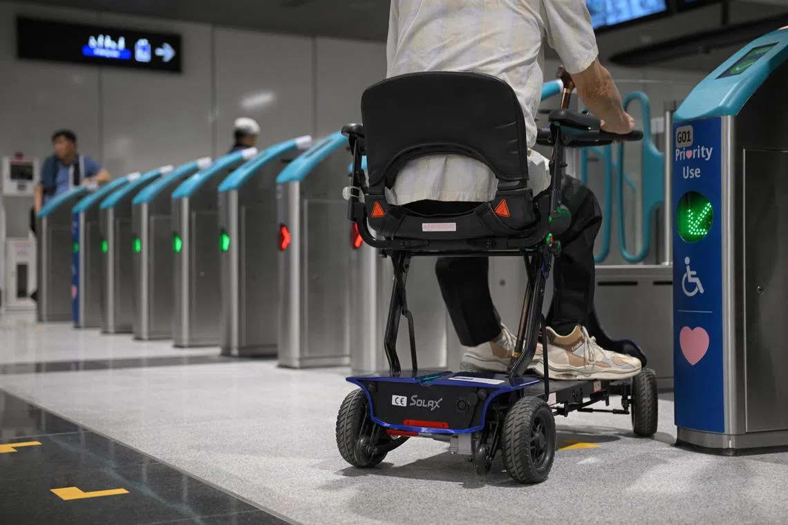 A commuter using a personal mobility device enters a gantry at Hume MRT Station on Feb 28, 2025. Can be used for stories on public transport, smrt, mrt, accessibility, mobility device, disability and Singapore.