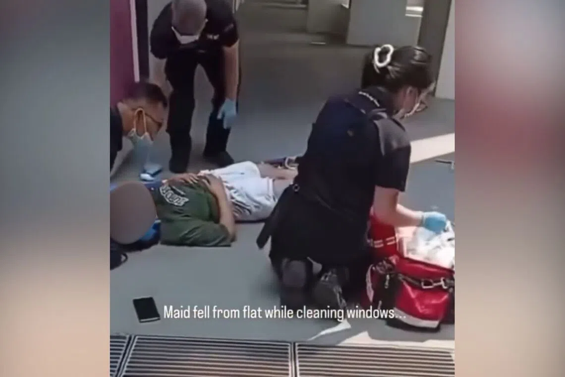 In an online video, a woman is seen lying at the foot of a building with a squeegee nearby.