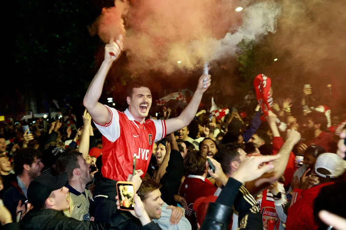 Arsenal fans celebrating their team winning the English Premier League, outside the Emirates Stadium in London on May 19, 2026. Arsenal celebrated their first Premier League title for 22 years late on May 19 after Manchester City were held to a 1-1 draw by Bournemouth, sparking wild scenes of joy around the Emirates Stadium.
