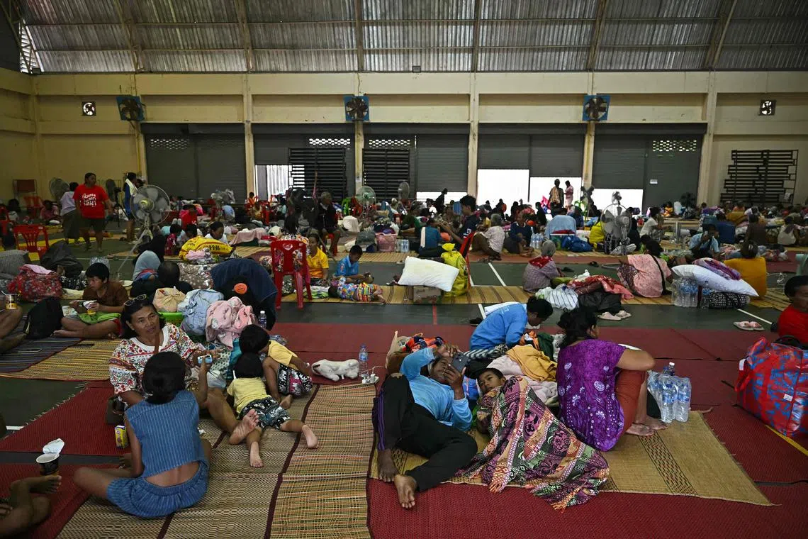 Evacuees rest as they take shelter in a gymnasium on the grounds of Surindra Rajabhat University in the Thai border province of Surin on July 25, 2025. 