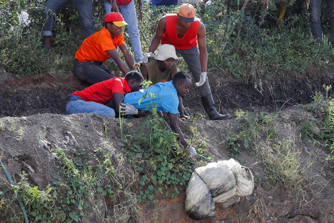 Volunteers carry a body of an unknown person retrieved, with seven others, from a dumpsite in Mukuru slums, in Nairobi, Kenya, July 12, 2024. REUTERS/Monicah Mwangi