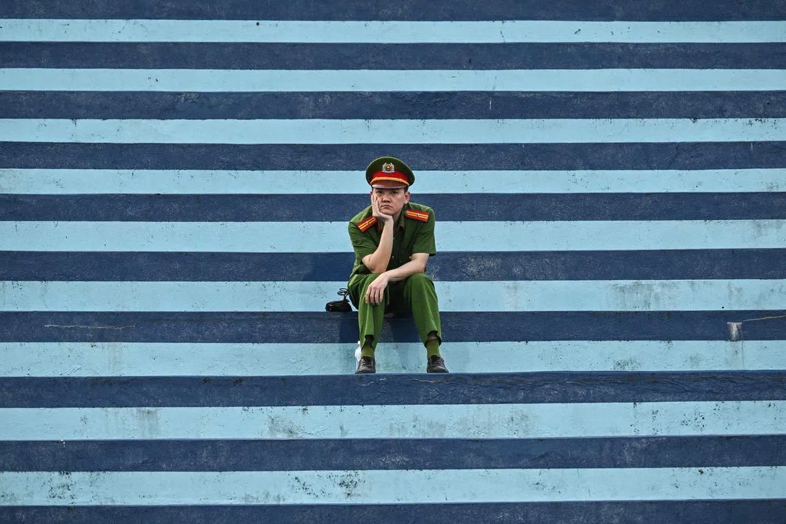A police officer resting as he sits before the AFC Asian Cup 2027 football match between Vietnam and Malaysia at Thien Truong Stadium in Ninh Binh Province, Vietnam on March 31, 2026. 