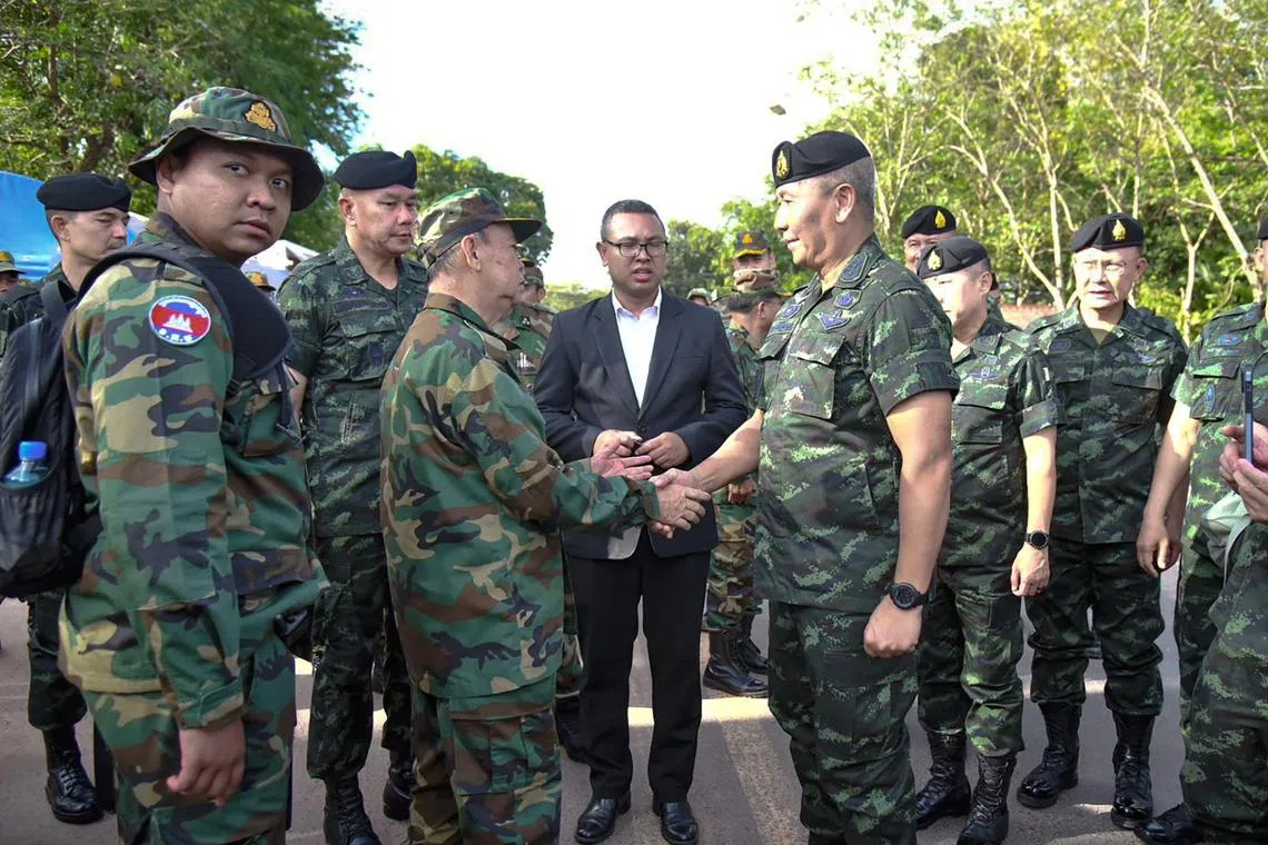 Royal Thai Army commander-in-chief General Pana Klaewplodthuk (right) and Cambodian General Mao Sophan  shaking hands at the Thai-Cambodian border in Kap Choeng district, Surin province, Thailand, on May 29, 2025. 