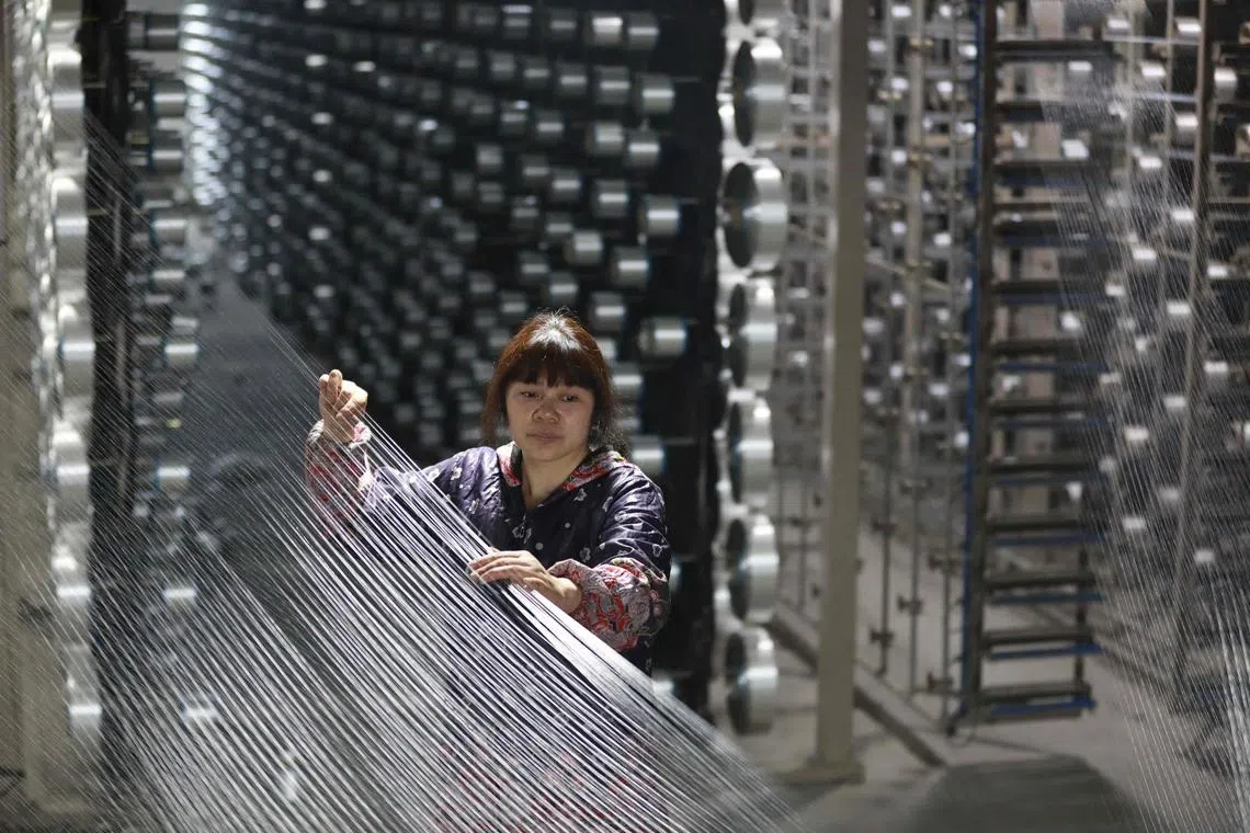 An employee works at a textile factory in Hangzhou, in eastern China's Zhejiang province on March 17, 2024. (Photo by AFP) / China OUT
