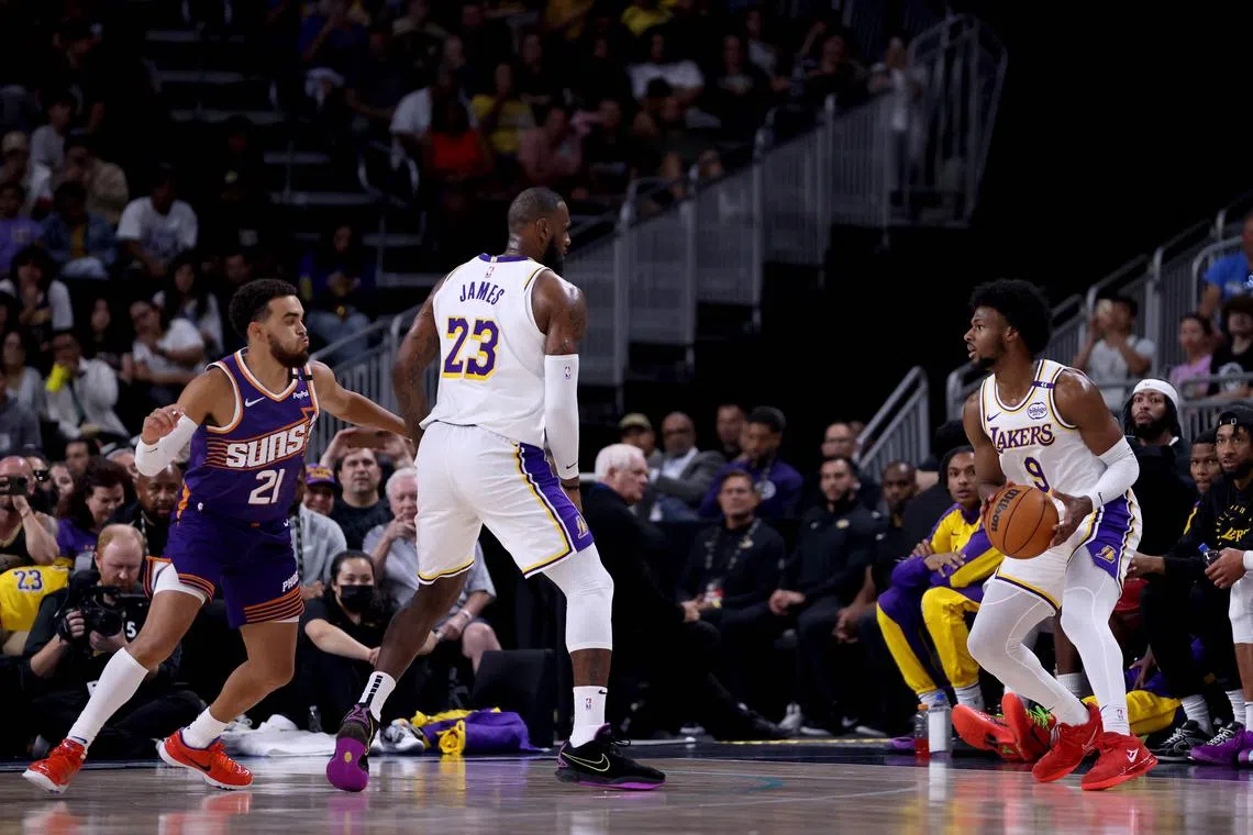 LeBron James of the Los Angeles Lakers setting a screen for his son Bronny James against Tyus Jones of the Phoenix Suns during the second quarter of an NBA pre-season game at Acrisure Arena on Oct 6.
