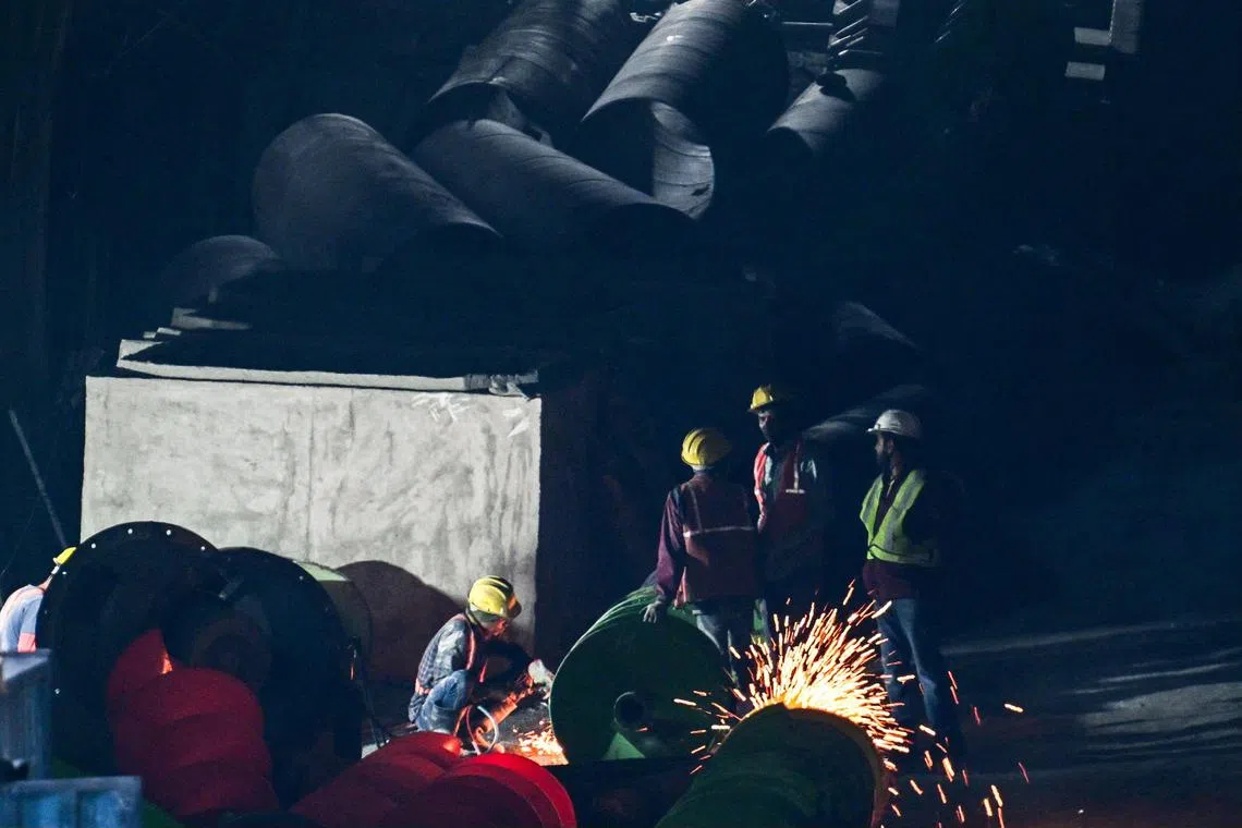 Rescue personnel working to free constructions workers trapped in a tunnel that collapsed in India's Uttarakhand state.