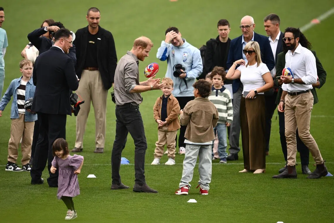 Prince Harry, the Duke of Sussex, plays with children during a visit with the Movember Foundation at Whitten Oval, in Melbourne, Australia.