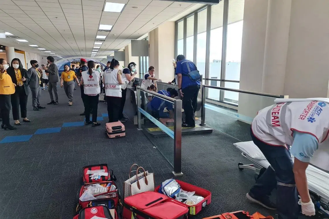 A handout photo released by Bangkok’s airport shows rescuers helping Ms Suphannee Kittirattana, 57, after her leg was caught in a moving walkway.