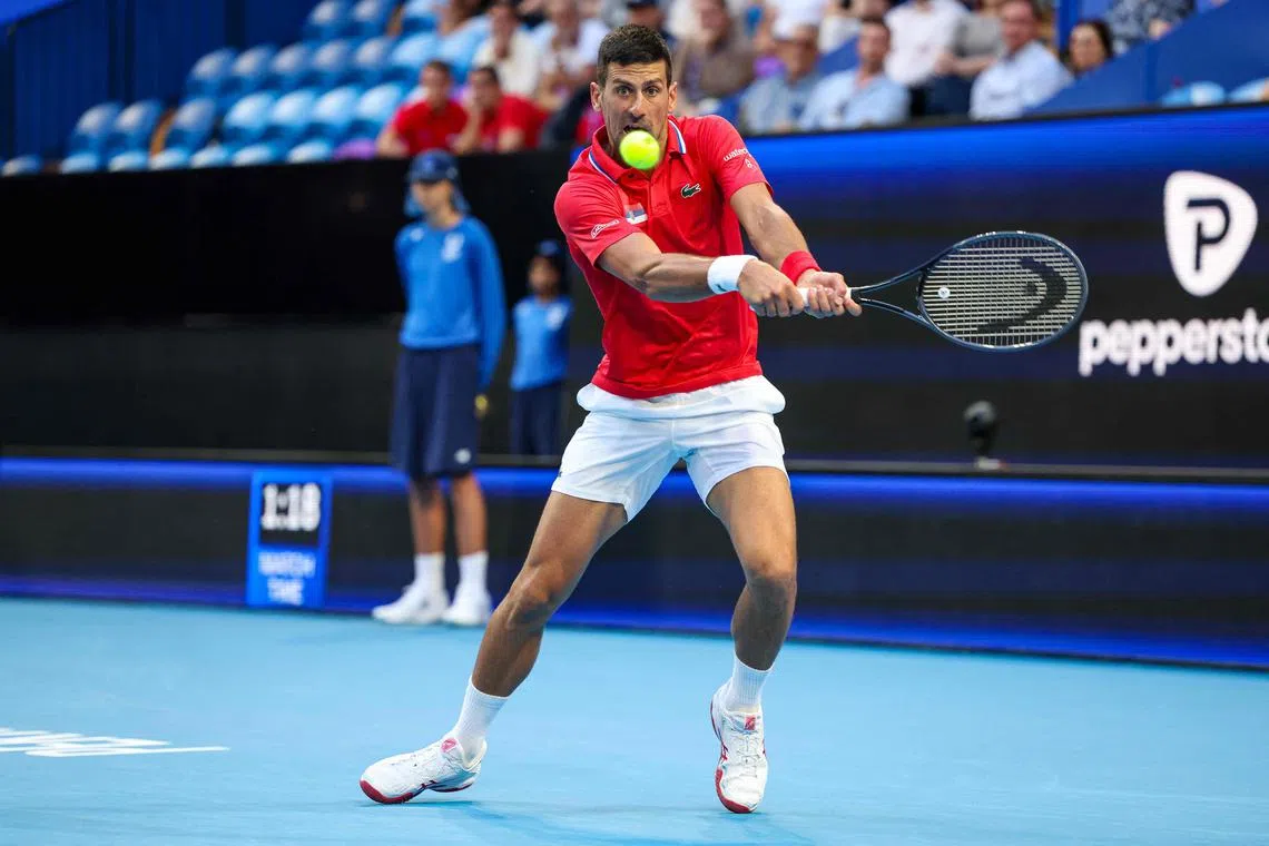 Serbia's Novak Djokovic hits a return against Australia's Alex de Minaur during their United Cup match.
