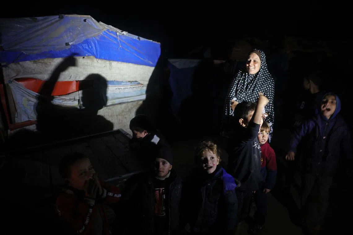 Palestinians celebrate at their refugee camp at Deir el-Balah in the central Gaza Strip, on Jan 15.