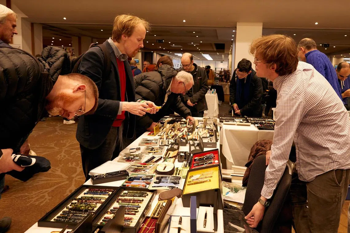 Customers view a selection of pens on display during the London Autumn Pen Show taking place in London, on Oct. 13, 2024. For collectors and enthusiasts at the London Pen Show, the finest writing instruments can cost thousands of dollars. (Ayesha Kazim/The New York Times)