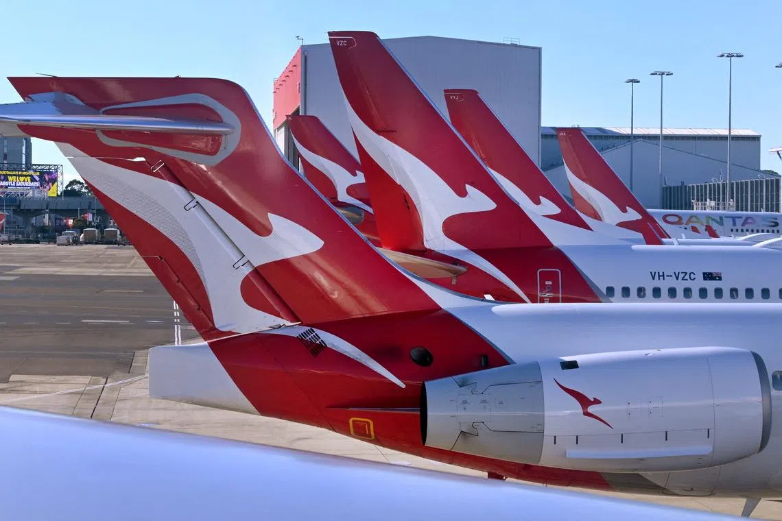 (FILES) A photo taken on August 20, 2023 shows a line-up of Qantas planes at Sydney�s Kingsford Smith Airport. Qantas reported a slide in half-year net profits on February 22, 2024, but said its reputation had "bounced back" under a new leader after taking a battering since the Covid-19 pandemic. (Photo by William WEST / AFP)