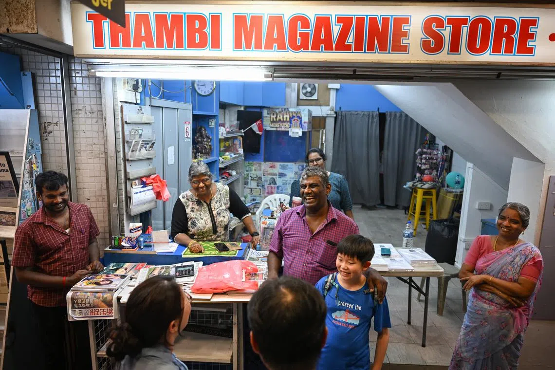 Thambi Magazine Store owner Periathambi Senthil Murugan with a young customer on May 5, before the shop closed for the last time.