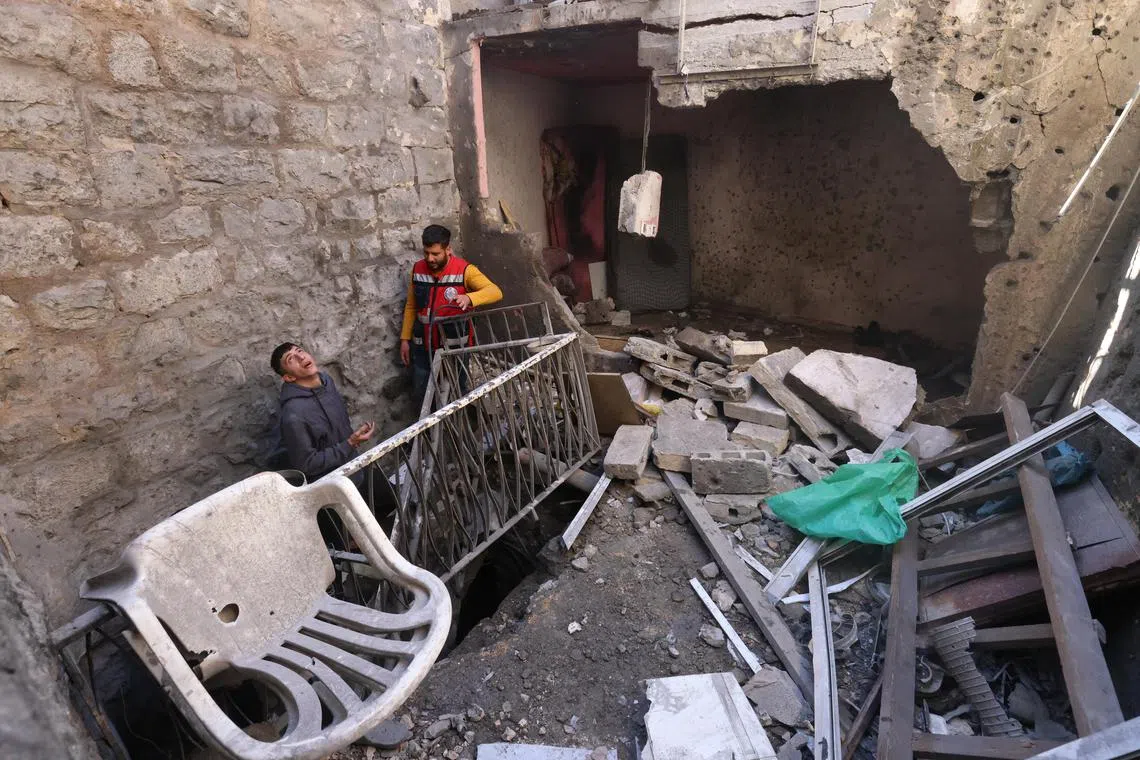 Palestinians inspect the damaged house where Israeli forces killed three Palestinians in a raid, in the old city of Nablus.