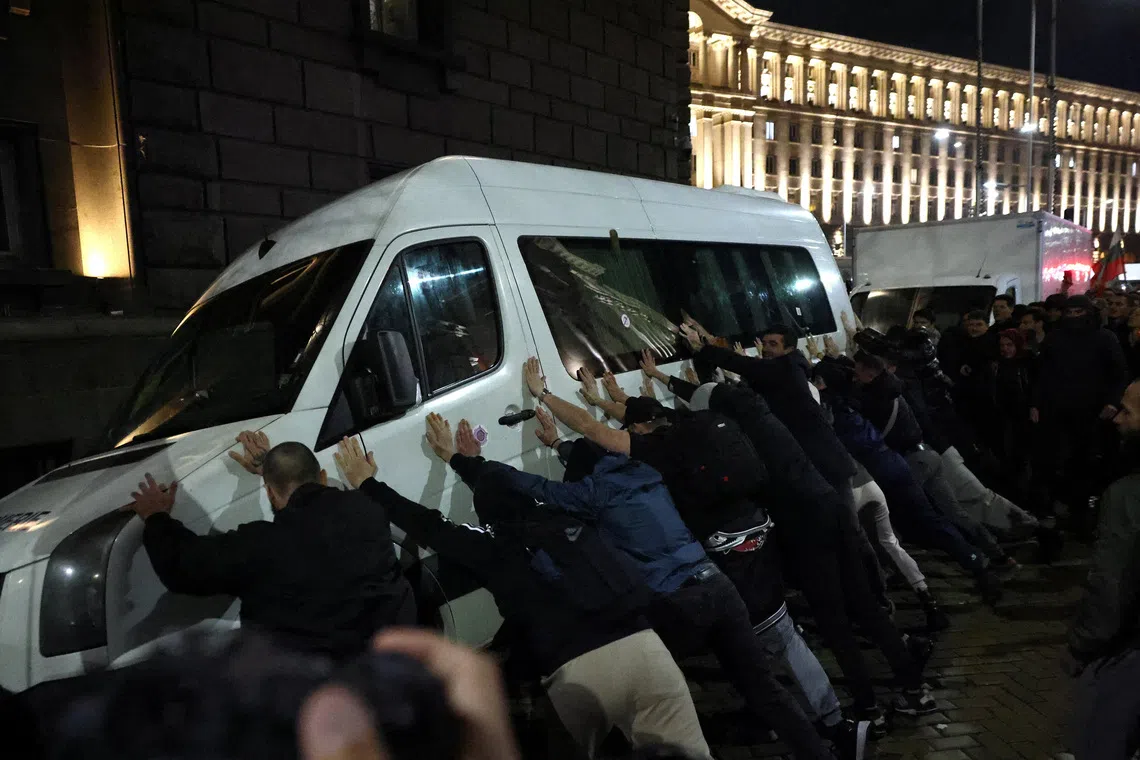 Protesters try to overturn a police vehicle during a demonstration organised by Bulgarian opposition parties and organisations against the proposed financial framework of the country's budget, outside the parliament, Sofia, Bulgaria. REUTERS/Stoyan Nenov